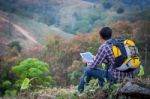 Tourists Look At A Map On The Tablet On Mountain Stock Photo