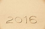 2016 Inscription Written In The Wet Yellow Beach Sand Stock Photo