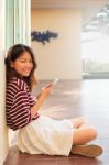 Portrait Of Beautiful Teen And Mobile Phone In Hand Sitting At H Stock Photo