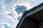 Gabled Roof Under A Cloudy Sky Stock Photo