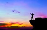 Silhouette Of A Man On The Rock At Sunset Stock Photo