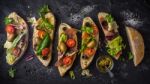 Slices Of Ciabatta With Olives , Tomatoes And Basil On The Black Stone Table Wide Screen Stock Photo