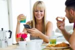 Happy Young Couple Enjoying Breakfast In The Kitchen Stock Photo