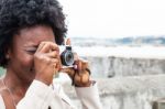 Young African Woman Shooting Her Vintage Camera Stock Photo