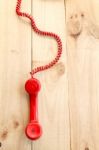 Red Landline Earphone And Cable On Wood Background Stock Photo