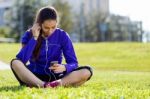 Pretty Young Woman Listening To Music After Running Stock Photo