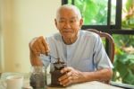 Asian Senior Man With Vintage Coffee Grinder Stock Photo