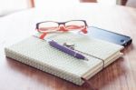 Notebook And Pen With Smartphone On Wooden Table Stock Photo