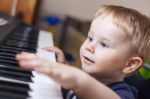 Small Boy Enjoys Playing Electric Piano Stock Photo