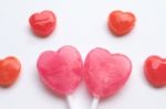 Pink Valentine's Day Heart Shape Lollipop With Small Red Candy In Cute Pattern On Empty White Paper Background. Love Concept. Colorful Hipster Style. Knolling Top View Stock Photo