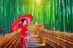 Bamboo Forest. Asian Woman Wearing Japanese Traditional Kimono At Bamboo Forest In Kyoto, Japan Stock Photo