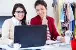 Two Young Businesswomen Working With Laptop In Her Office Stock Photo