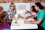 Cheerful Family Of Four Enjoying Breakfast Stock Photo