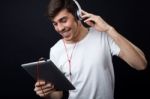 Young Beautiful Man Listening To Music. Isolated On Black Stock Photo