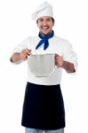 Smiling Male Cook Holding A Saucepan And Ladle Stock Photo