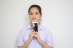 Portrait Of Thai High School Student Uniform Teen Beautiful Girl Using Her Phone And Smile Stock Photo