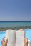 Girl Reading A Book On A Beach Stock Photo