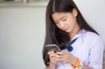 Portrait Of Thai Student Teen Beautiful Girl Using Her Phone And Smile Stock Photo