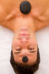 Young Man Receiving Stone Treatment Spa Stock Photo