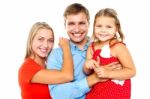 Cheerful Family Of Three Facing Camera And Smiling Stock Photo