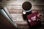 Gift Box, Notebooks And Coffee On Wooden Plank Stock Photo