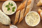 Baguette With Herb Butter And Rosemary Thyme On Rustic Wooden Background Stock Photo