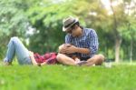 Full Length Of Happy Female Lying On Happy Man Lap In Park Stock Photo