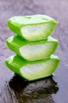 Slice Aloe Vera On Wet Wood Background Stock Photo