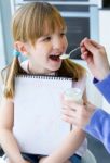 A Young Woman And Little Girl Eating Yogurt In The Kitchen Stock Photo