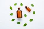 Mint Essential Oil In A Glass Bottle With Leaves On White Backgr Stock Photo