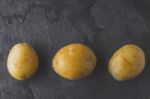 Potatoes On The Dark Stone Table Top View Stock Photo