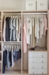 Clothes Hanging In Wooden Wardrobe Stock Photo