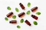 Mint Essential Oil In A Glass Bottle With Leaves On White Backgr Stock Photo