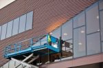 Builder On A Scissor Lift Platform At A Construction Site Stock Photo