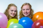 Two Girls Heads Behind Colored Balloons Stock Photo