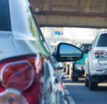 Sea View In Side Mirror Of Car With Traffic Jam Stock Photo