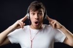 Young Beautiful Man Listening To Music. Isolated On Black Stock Photo