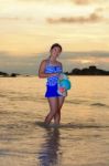 Girl On The Beach At Sunrise Over The Sea Stock Photo