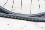 Bicycle Wheel With Flat Tyre On The Concrete Road Stock Photo