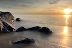 Beautiful Seascape Of Wave And Rock On Beach With Sunrise Stock Photo