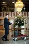 Concierge Pushing The Luggage Cart Stock Photo