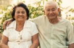 Happy Senior Couple Sitting Outdoors Stock Photo