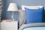 Blue Pillow On Bed With Glass Lamp On White Table In Modern Blue Stock Photo