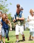 Grandson Riding On Grandfathers Shoulders Stock Photo