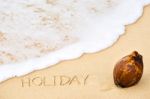 Inscription Of Word Holiday Written On Wet Yellow Beach Sand And Stock Photo