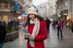 Woman In Red Coat And Wool Cap And Gloves With Smartphone In Han Stock Photo