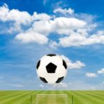 Soccer Ball With Soccer Field Against  Blue Sky Background Stock Photo