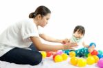 Baby Girl Is Playing Ball With Her Mother On White Background Stock Photo