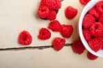 Bunch Of Fresh Raspberry On A Bowl And White Table Stock Photo