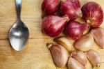 Garlic And Spoon On Chopping Block Stock Photo